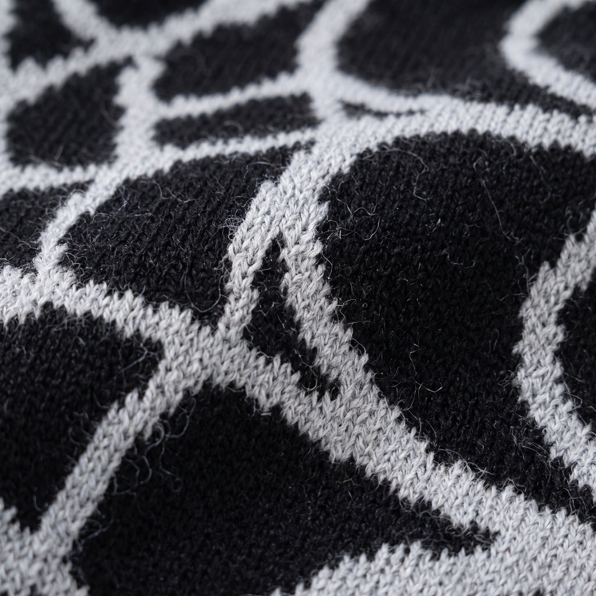 Black and ash jacquard web knit beanie showing the knitted-through pattern