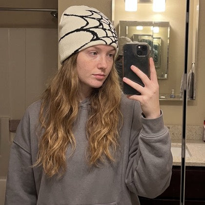Bone and black web beanie styled indoors